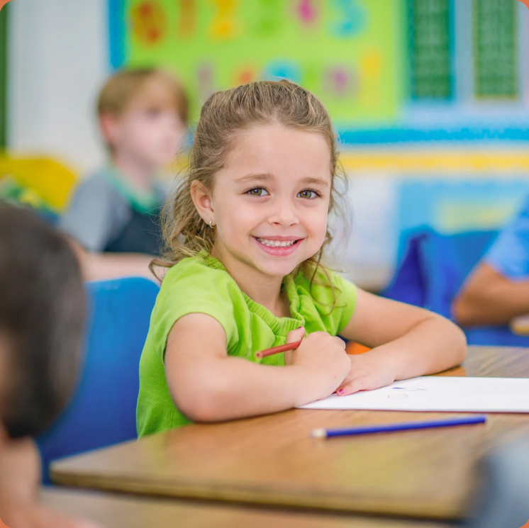 Uśmiechnięta dziewczynka w klasie podczas zajęć